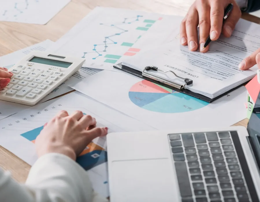 partial-view-of-man-studying-loan-agreement-and-businesswoman-using-calculator-while-sitting-at.jpg